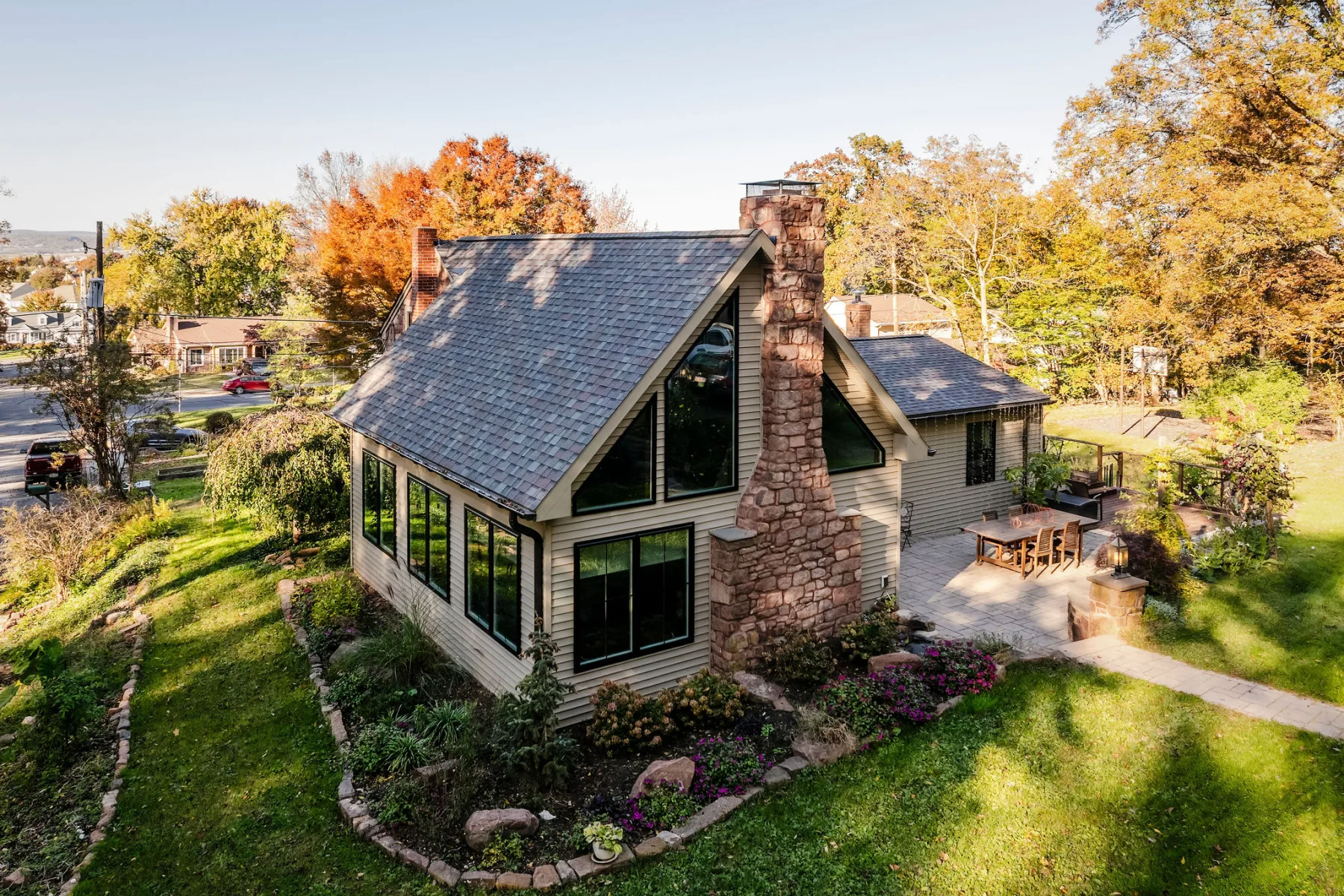 Historic A-frame addition with stone chimney in autumn